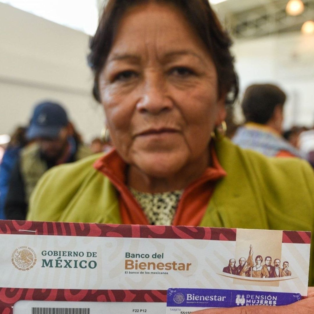 Una mujer con una tarjeta y un sobre vino.