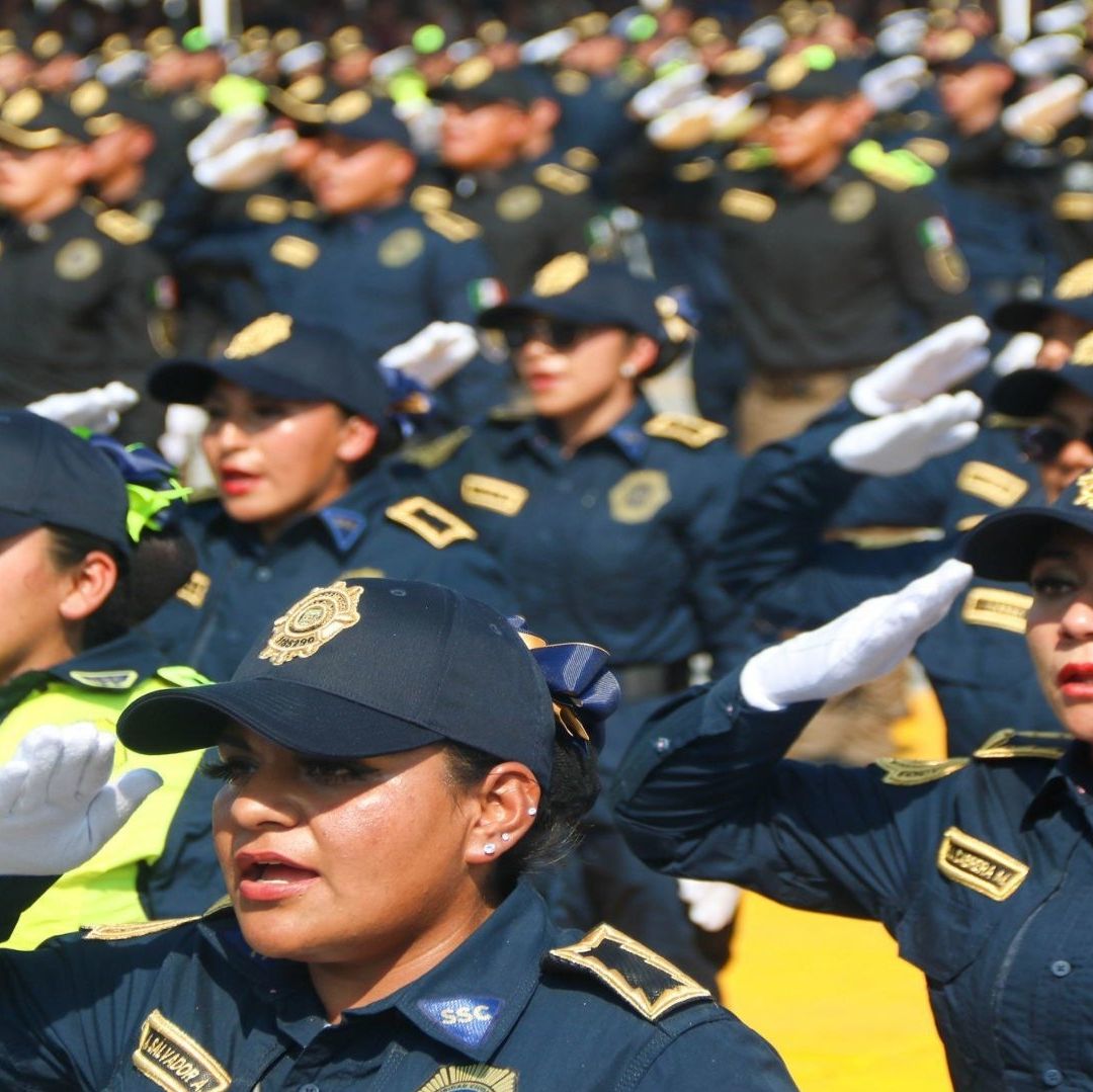 Policías formadas, visten con un uniforme de color negro con gorra.