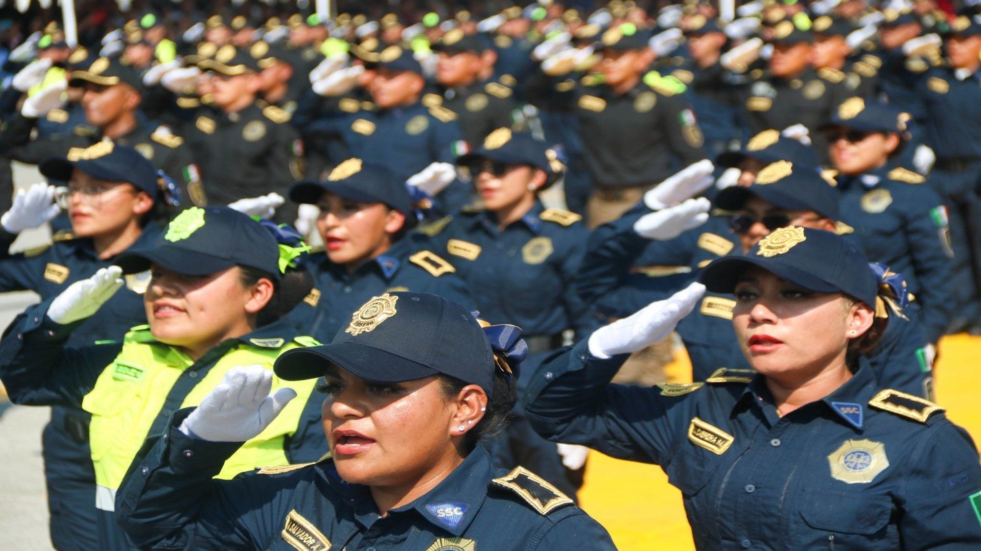 Policías formadas, visten con un uniforme de color negro con gorra.