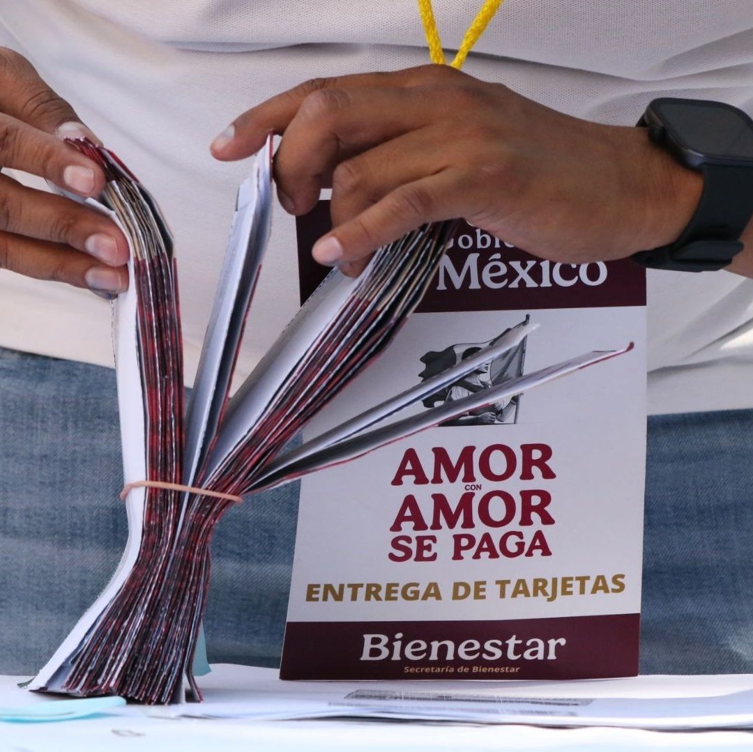 Una persona agarra varios sobres que deicen "entrega de tarjetas".