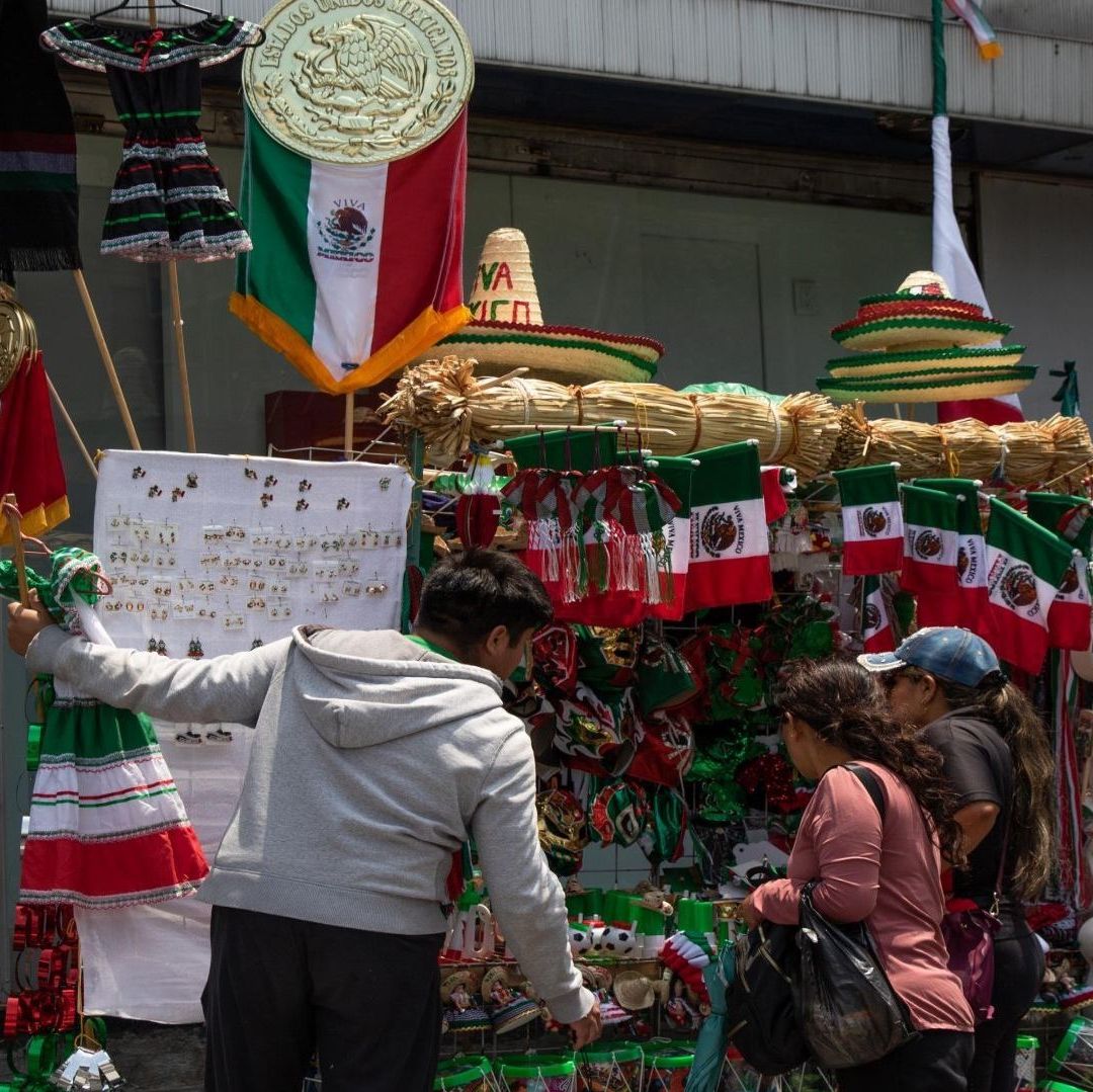 Personas comprando adornos de colores verde, blanco y rojo.