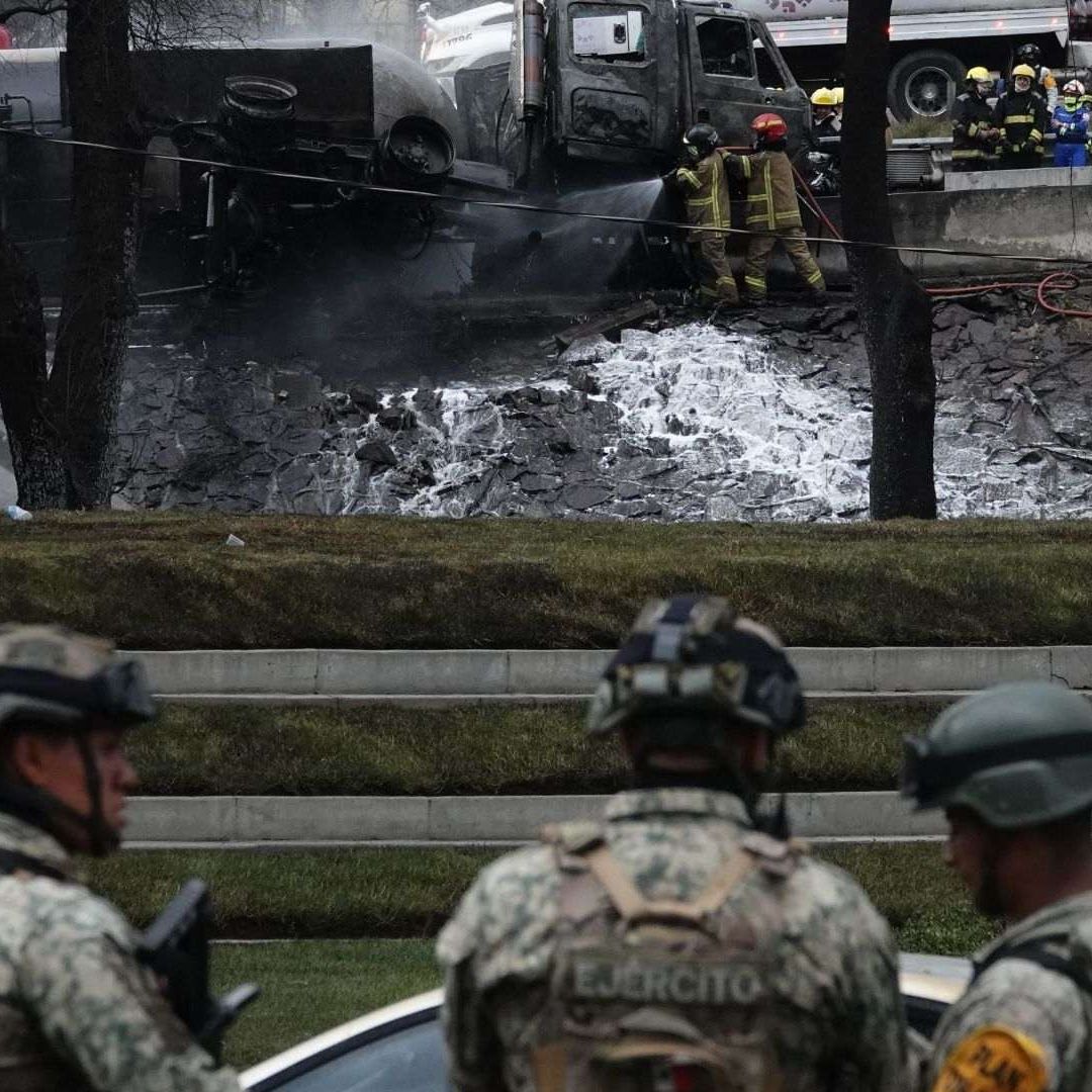 Elementos del Ejército se encuentran en una zona donde hay un vehículo destrozado por llamas que ya fueron sofocadas.