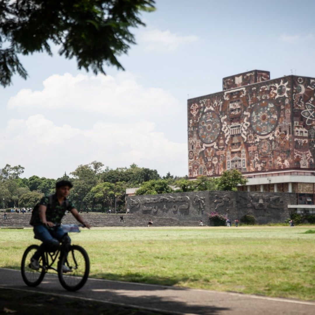 Un hombre pasea en una bicicleta en Ciudad Universitaria, UNAM.
