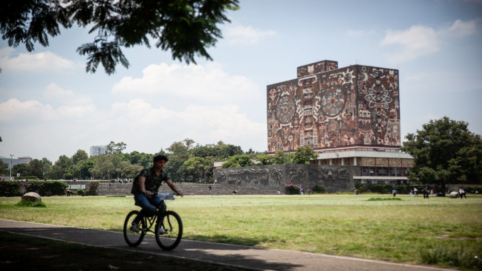 Un hombre pasea en una bicicleta en Ciudad Universitaria, UNAM.