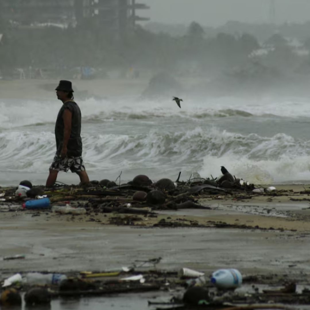 Un hombre camina en las playas de Guerrero mientras siguen los efectos de John
