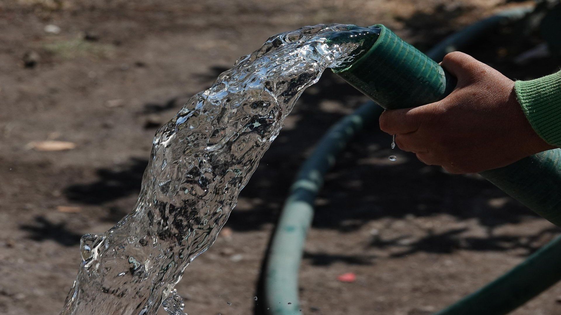 Una persona sosteniendo una manguera de agua.