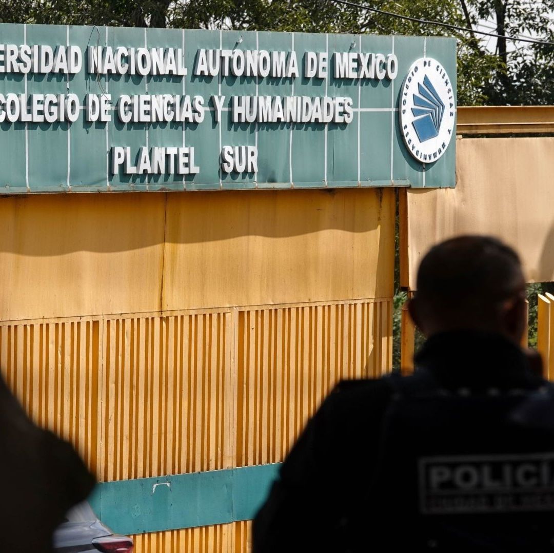 Un policía viendo una escuela con puertas amarillas.