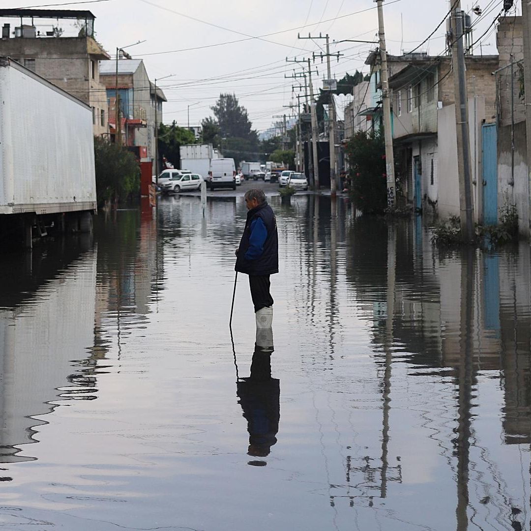 Una persona intenta destapar coladera en la colonia Santa María Aztahuacán, Iztapalapa, ante inundación. Foto: Cuartoscuro