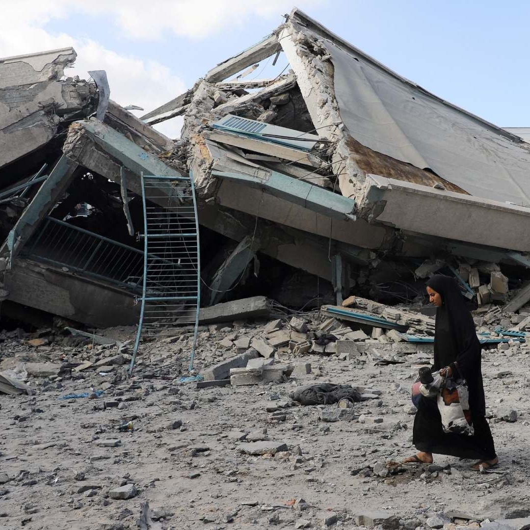 Persona camina cerca de edificio destruido en Gaza