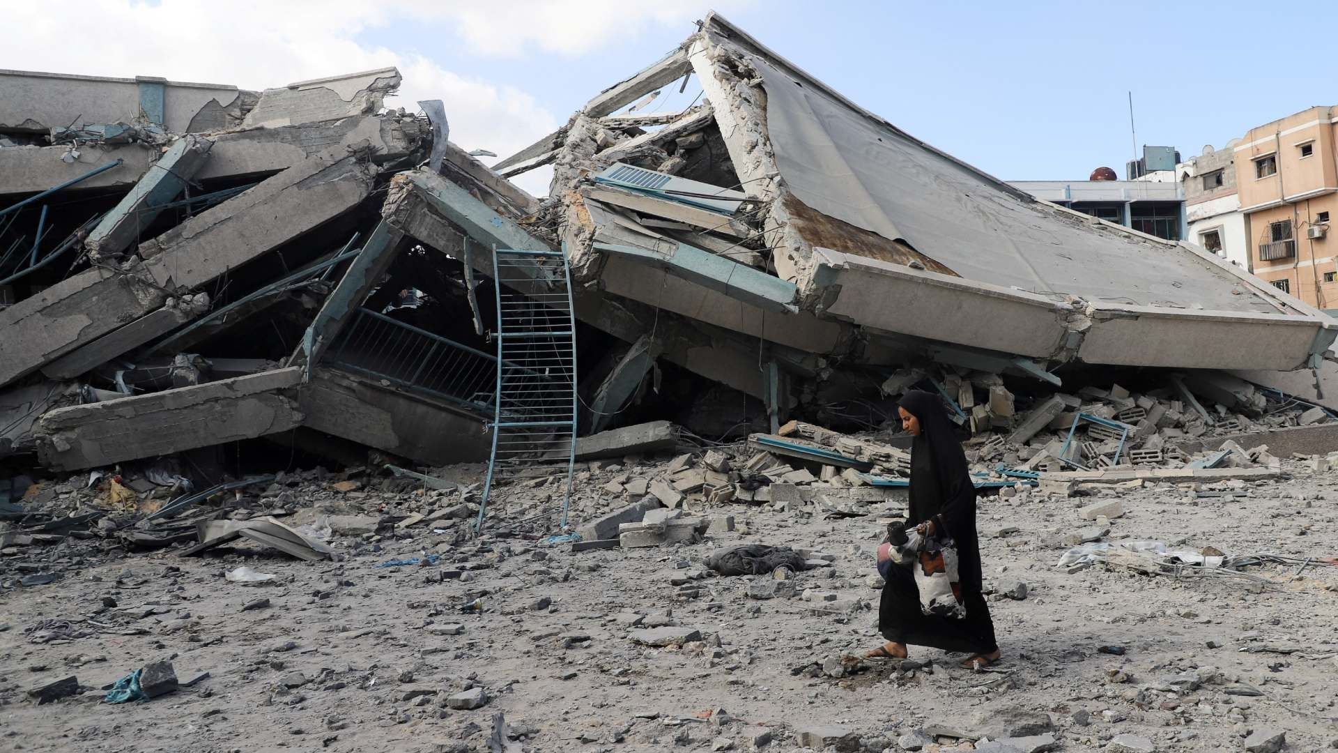 Persona camina cerca de edificio destruido en Gaza
