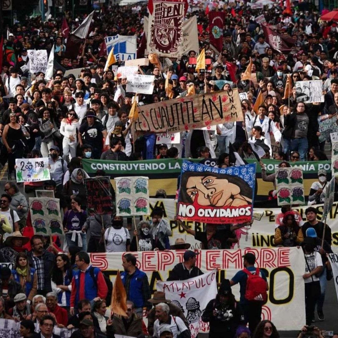 Varios estudiantes portan carteles.