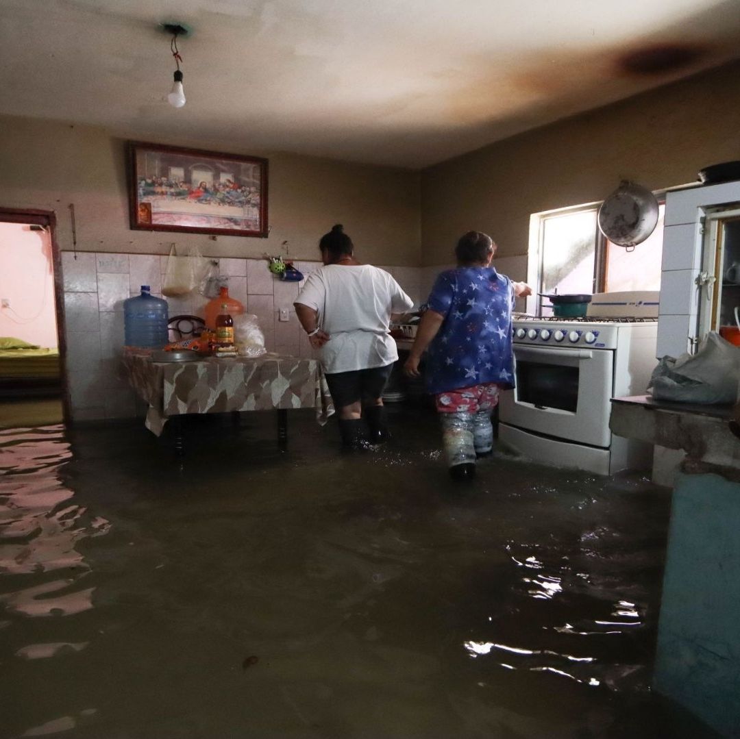 Una casa inundada y dos mujeres que se encuentran observando los muebles.
