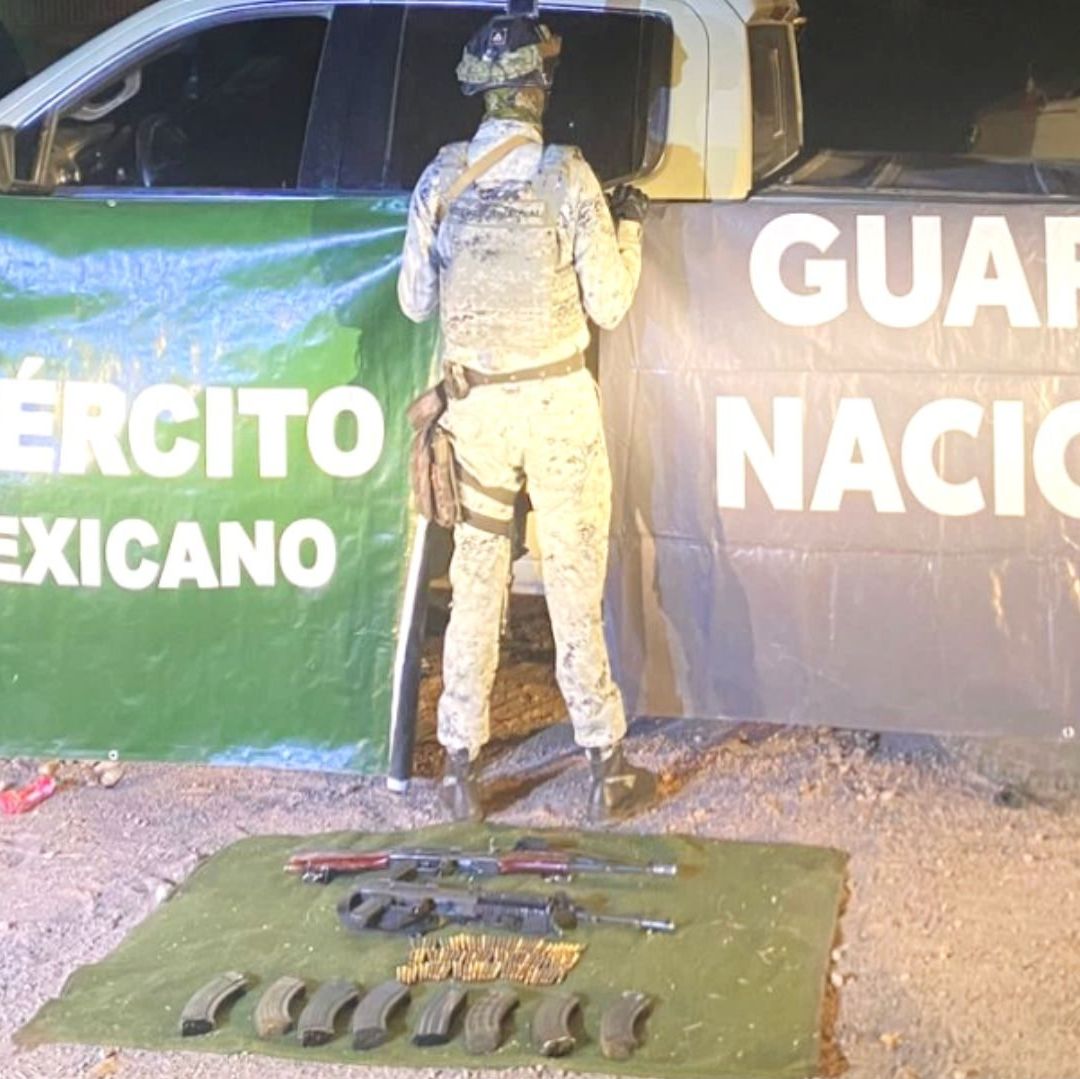 Dos hombres sostienen un cartel que dice Guardia Nacional.