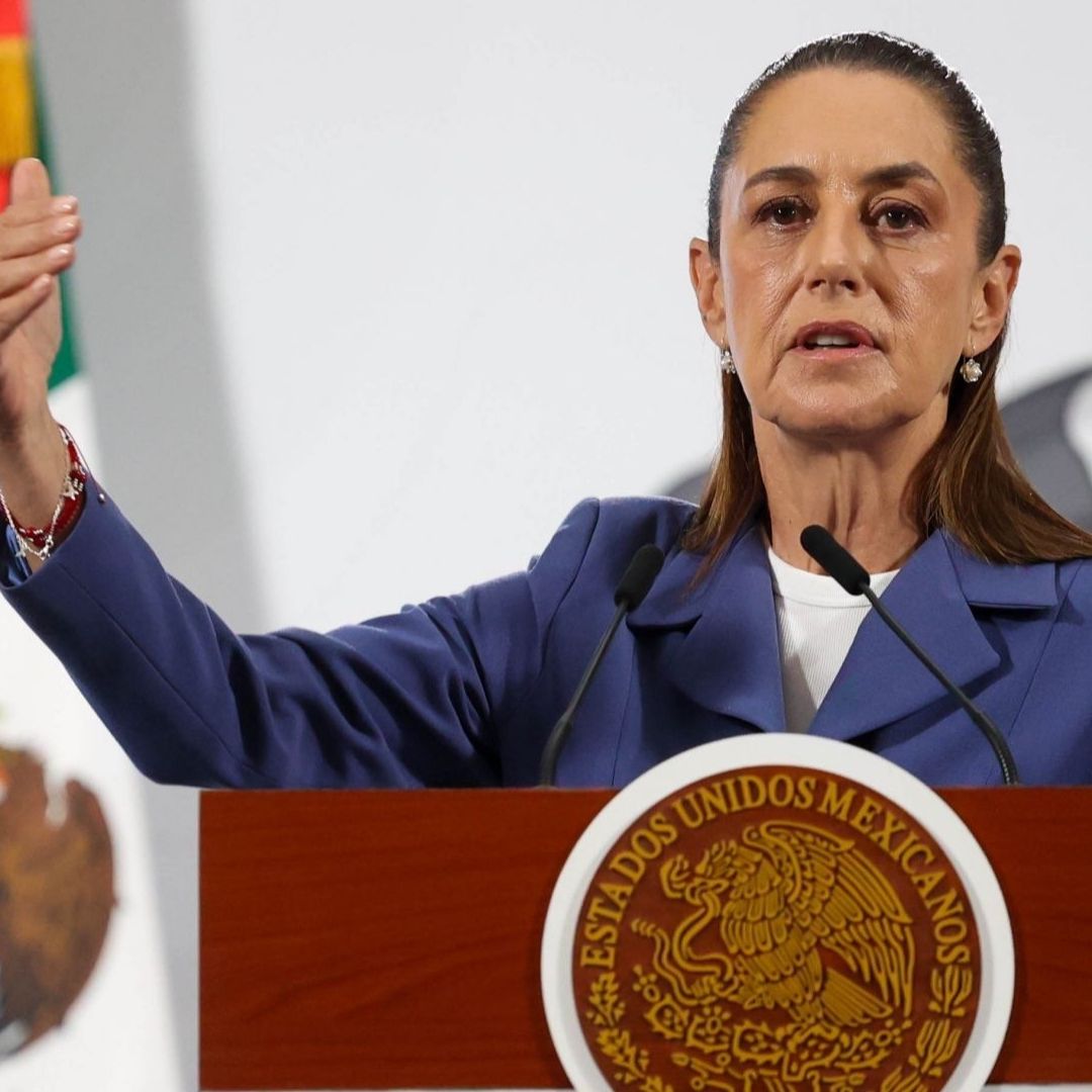 Claudia Sheinbaum levanta el brazo durante la conferencia de prensa