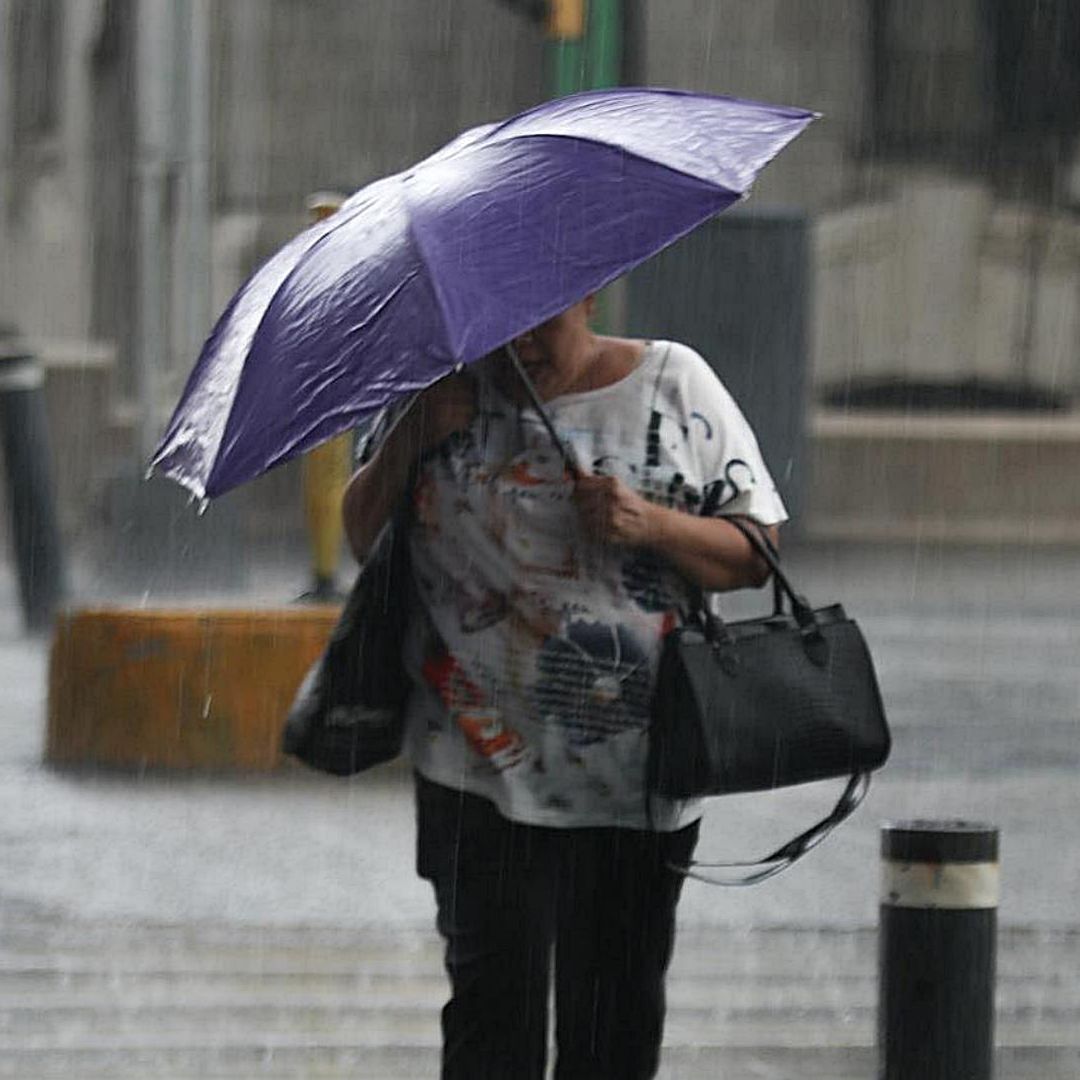 Mujer se cubre de la lluvia en el Centro Histórico de la CDMX el 9 de septiembre de 2025