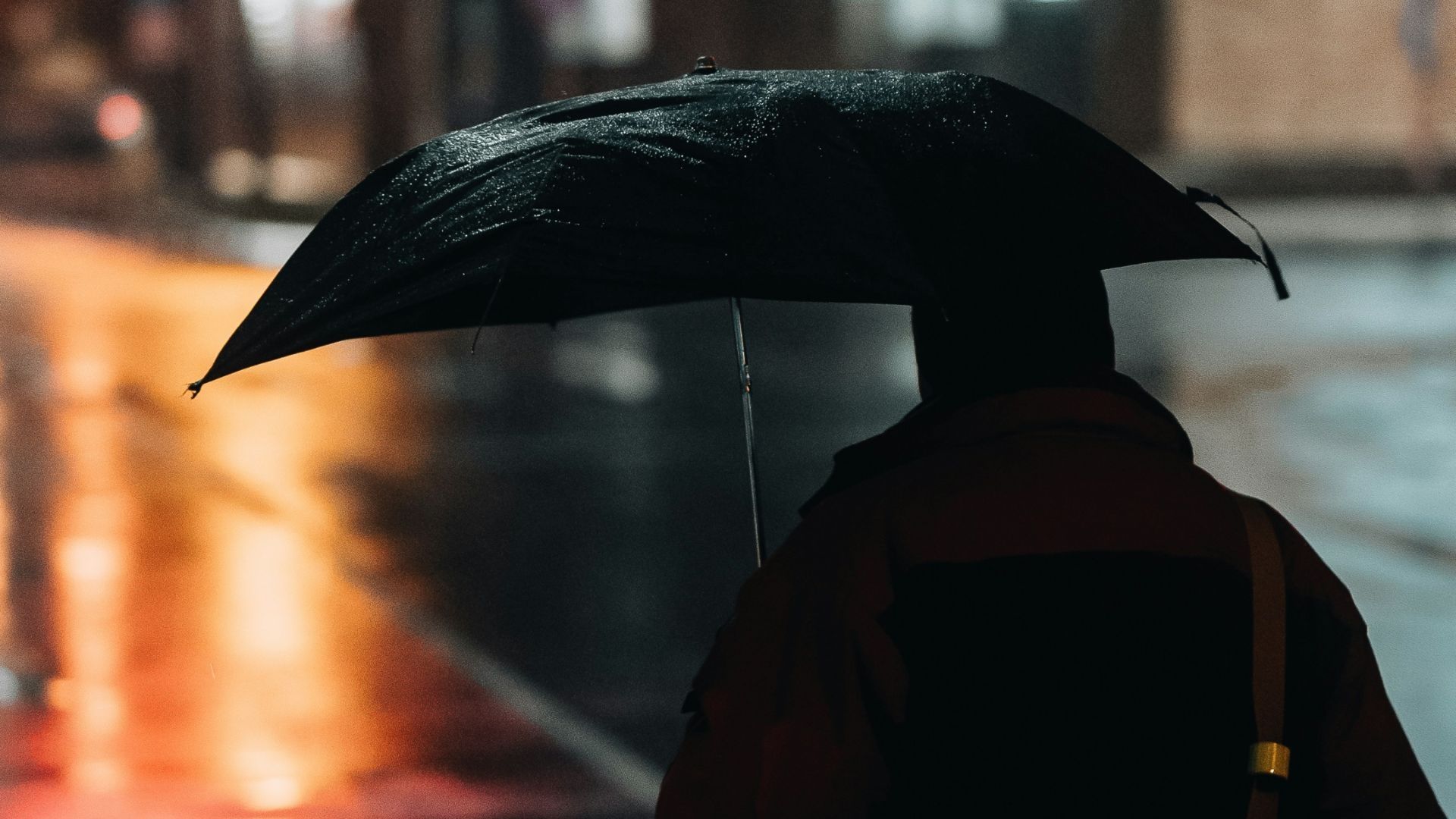 Persona con sombrilla bajo la lluvia
