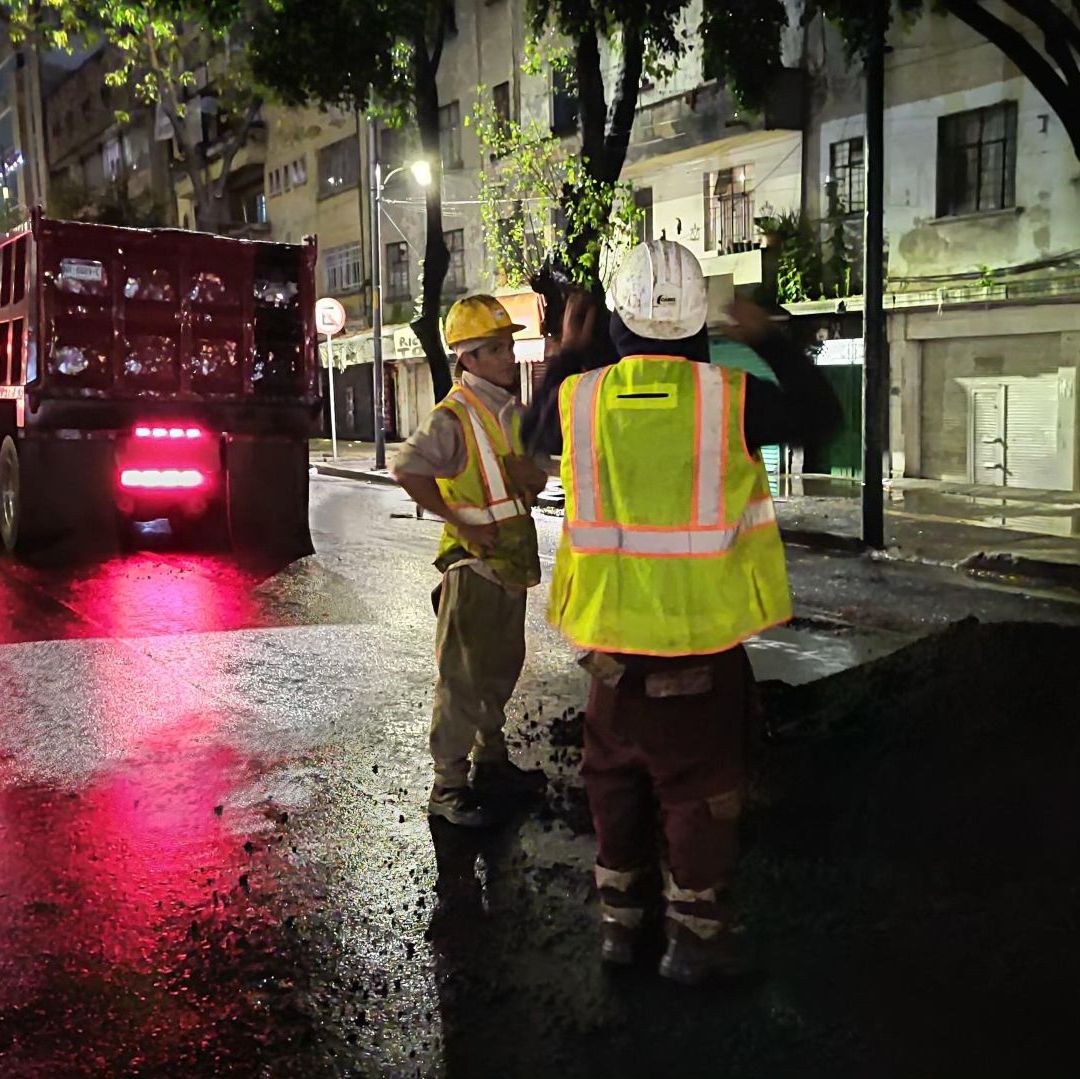 Trabajadores reparan las calles en la noche.