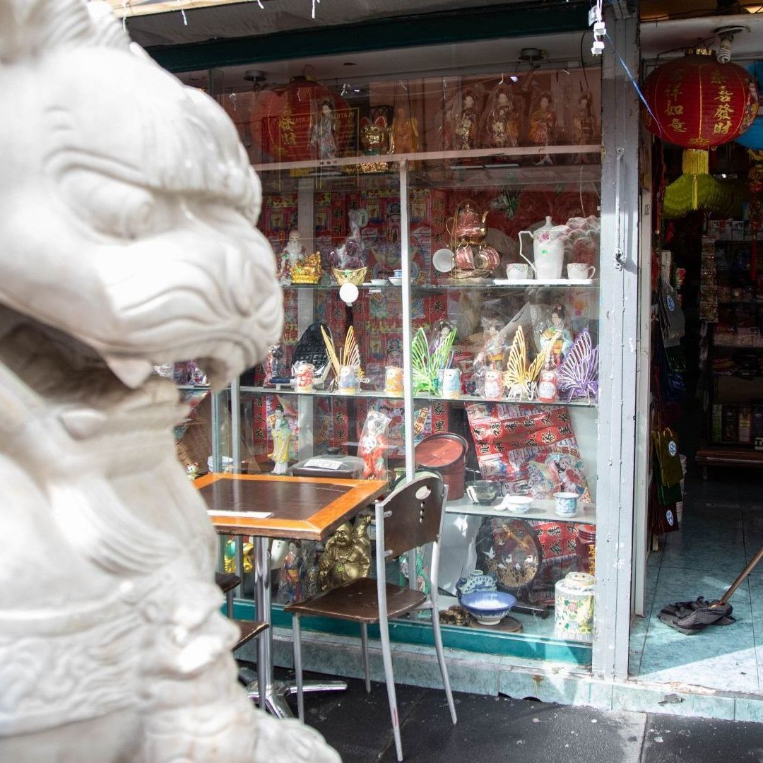 Una persona limpia el piso de una tienda, usando un trapeador