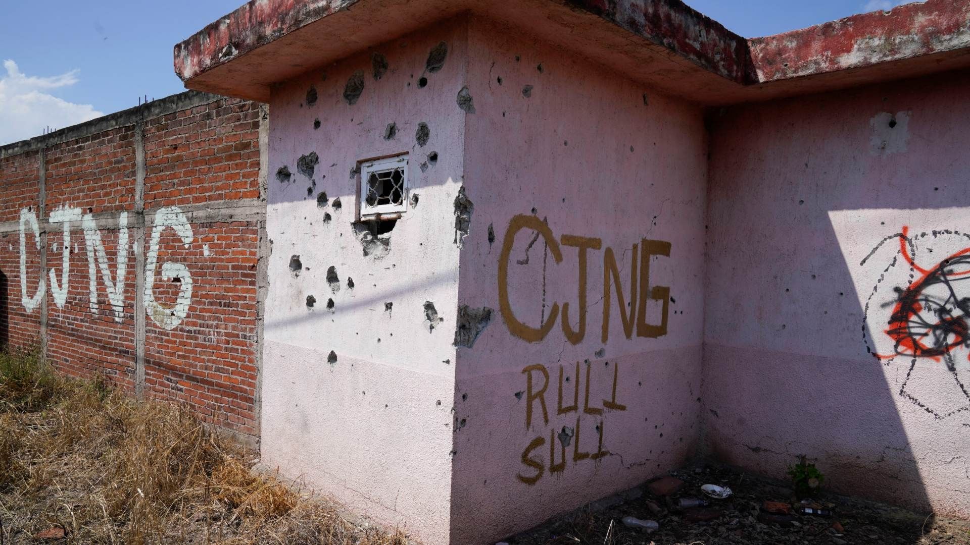 Fachada baleada y con las siglas CJNG