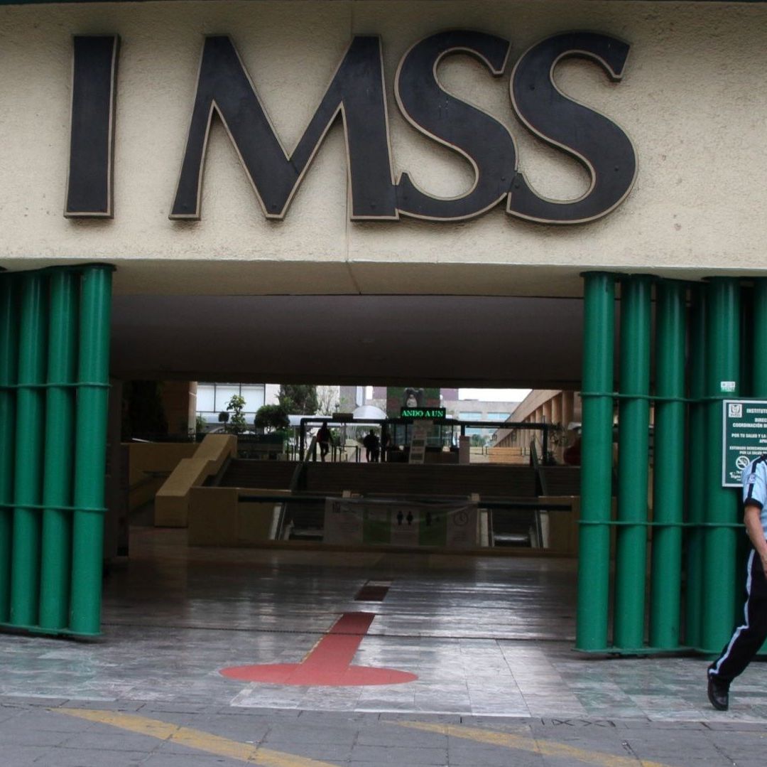 Un policía afuera de un inmueble que dice IMSS.