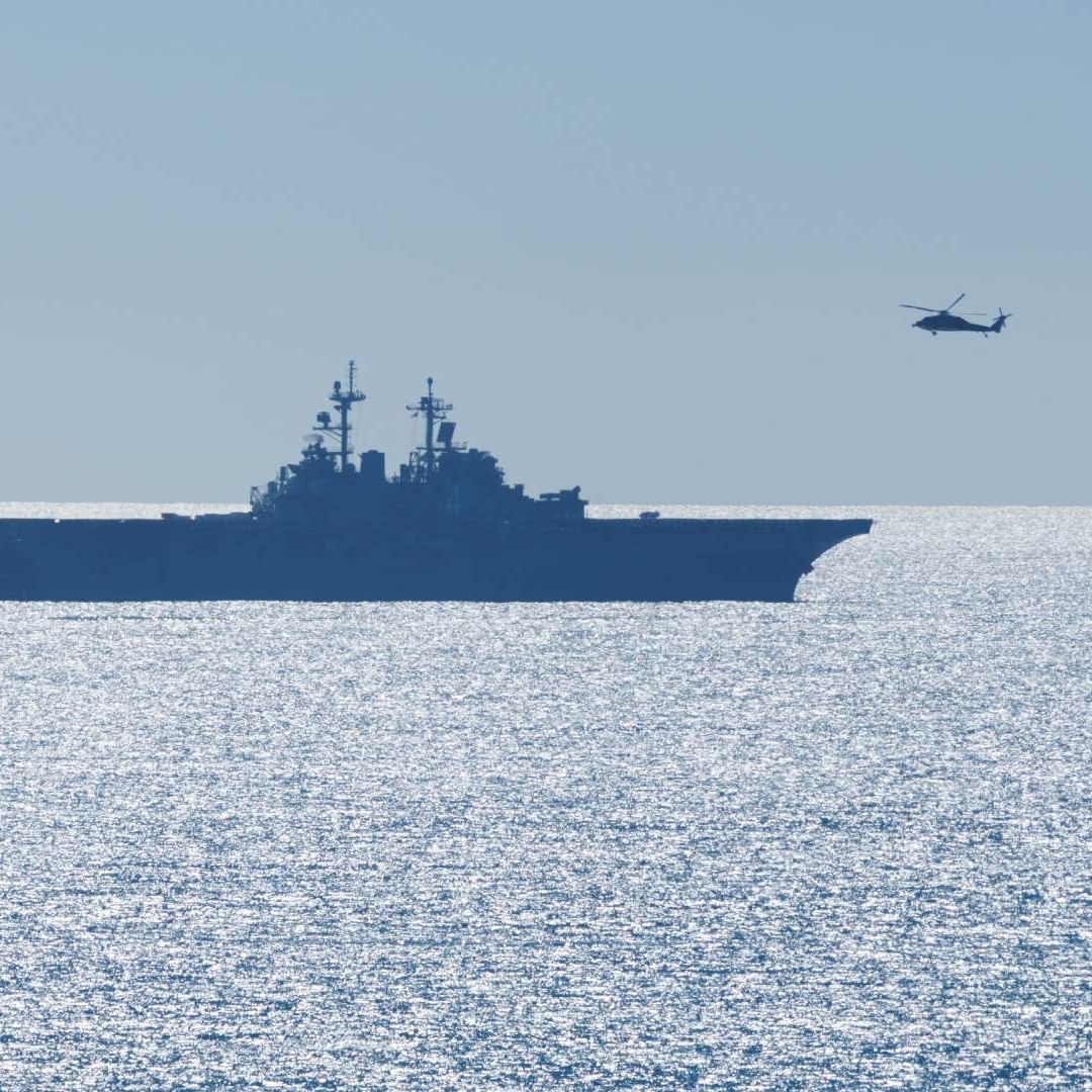Un helicóptero se acerca a un barco de asalto, como parte de un entrenamiento frente a costas de California