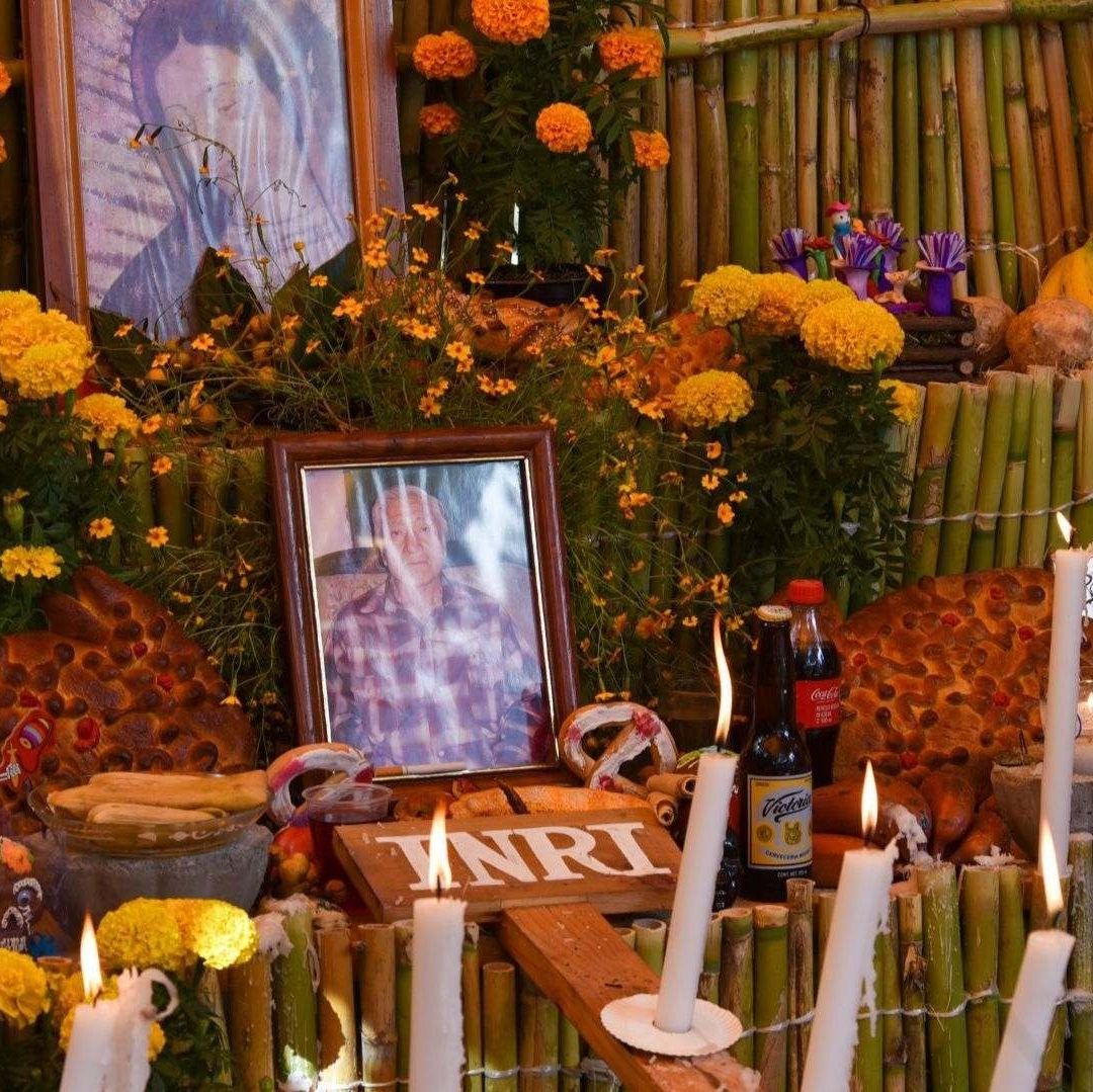 Una ofrenda de Día de Muertos, donde predominan los colores naranja y amarillo.