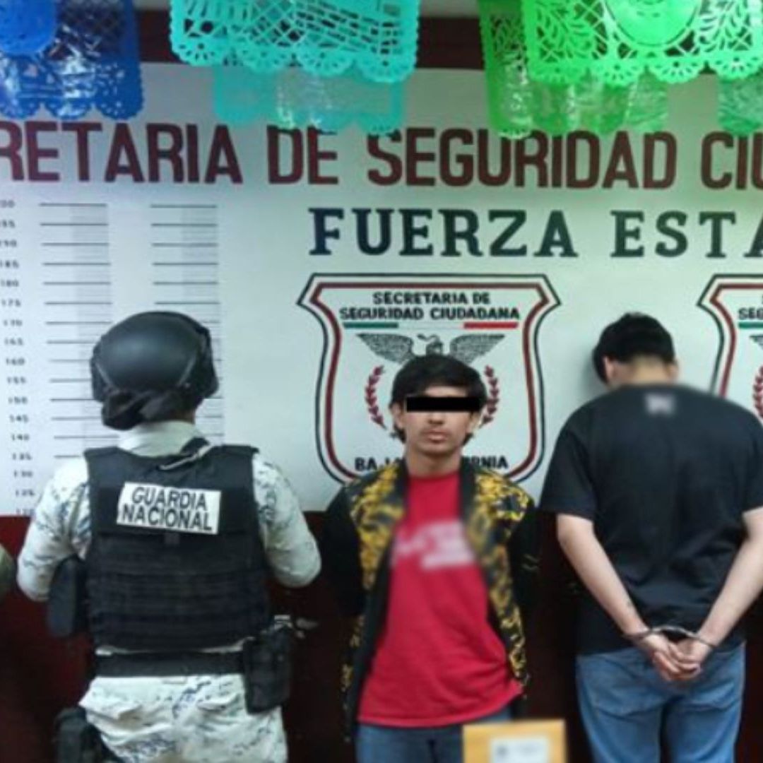 Un hombre es asegurado por dos sujetos.