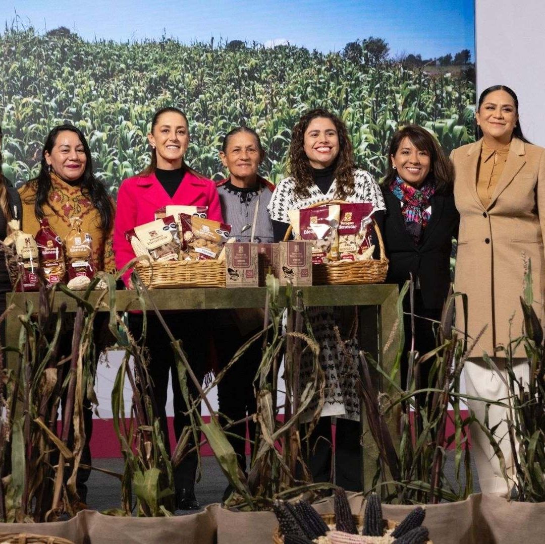 Varias mujeres posan para una foto al lado de maíz.