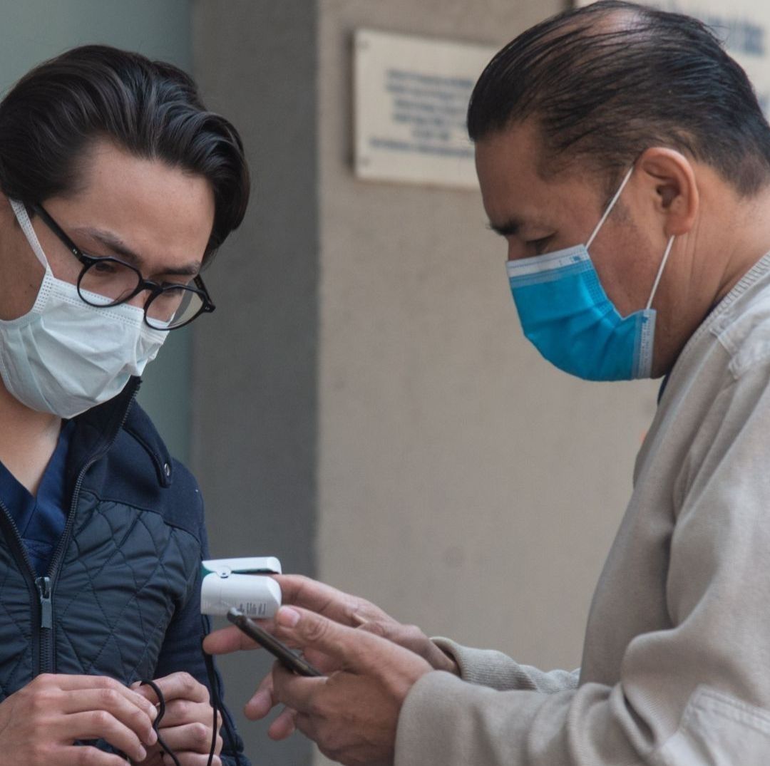 Dos personas con cubrebocas en revisión médica.