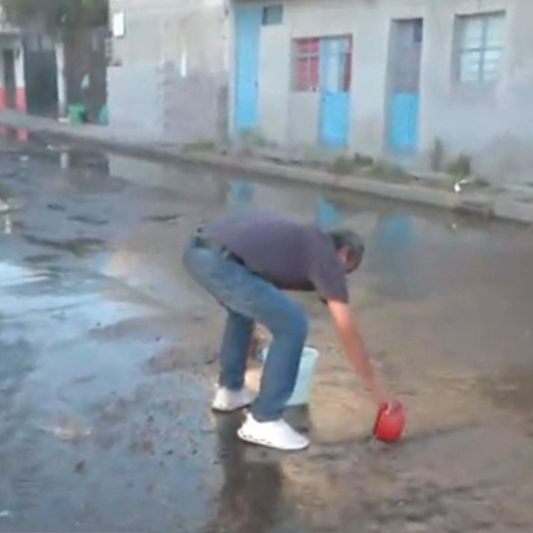 Vecinos de Ecatepec sacan agua de una fuga