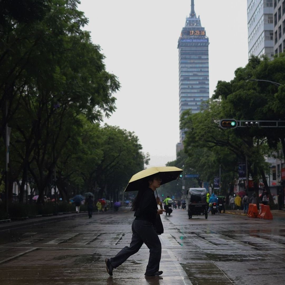 Persona camina en el Centro de CDMX en medio de la lluvia