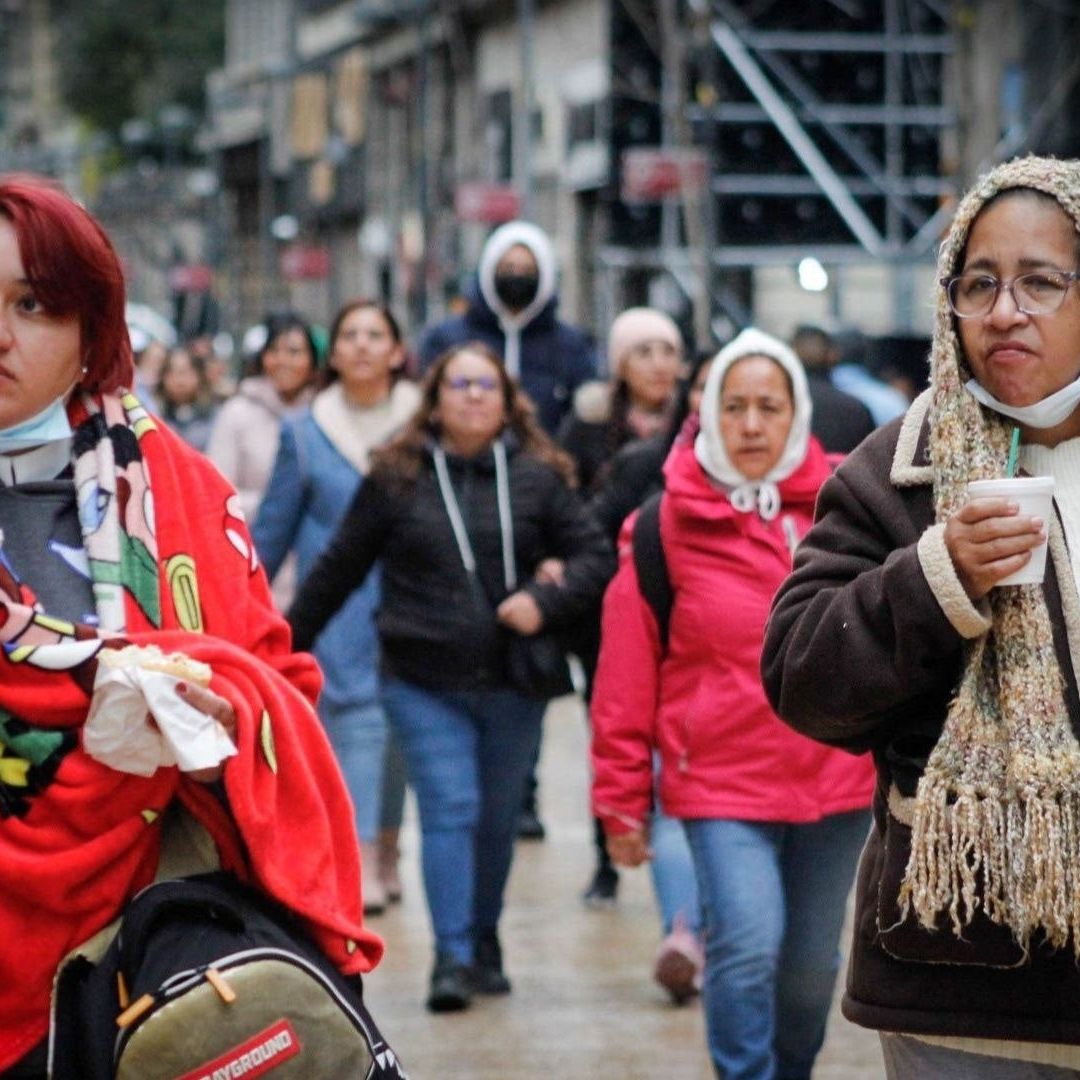 Personas caminan por las calles abrigadas.