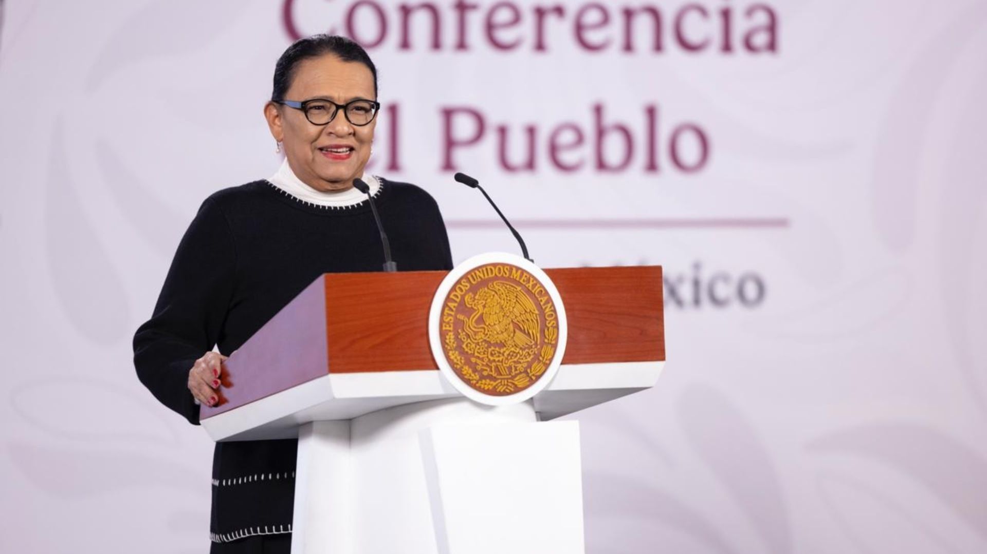Una mujer habla por micrófono.
