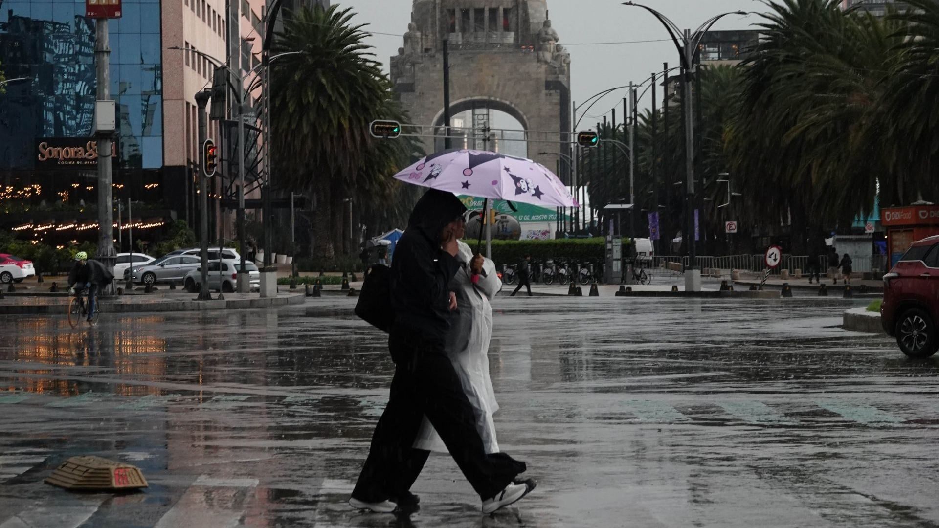 Personas caminan bajo la lluvia en calles de Ciudad de México