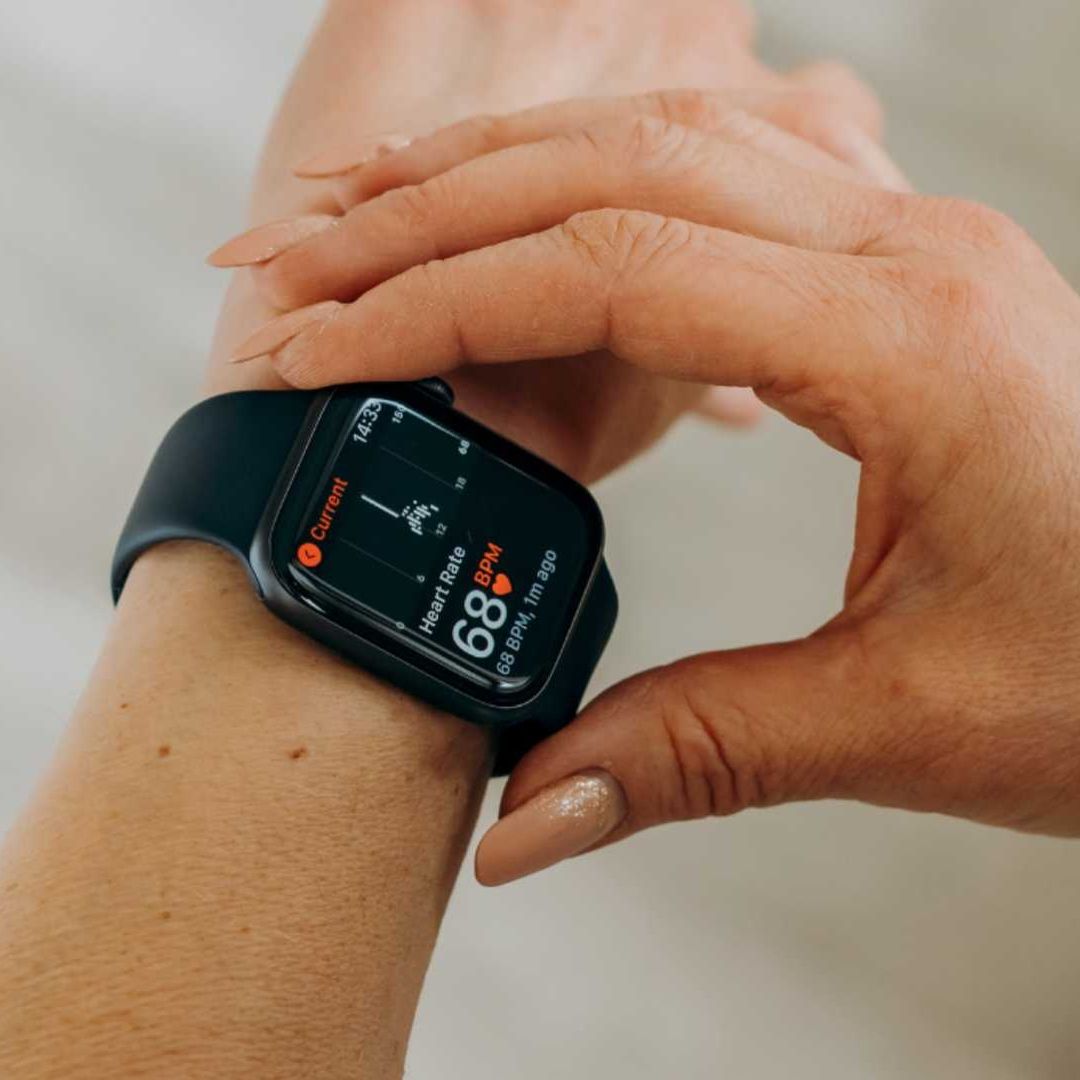 Mujer consulta su frecuencia cardíaca en el reloj