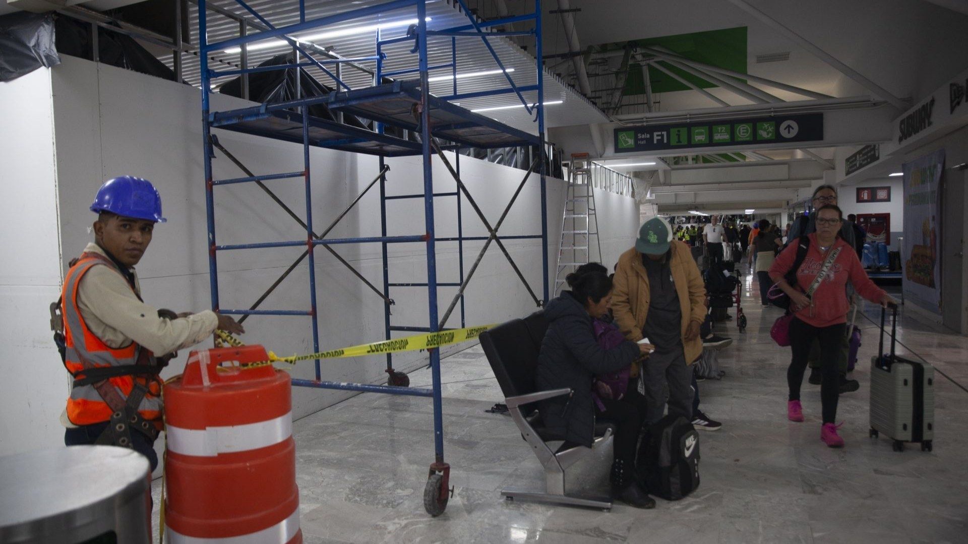 Personas caminan por la sala de un aeropuerto.
