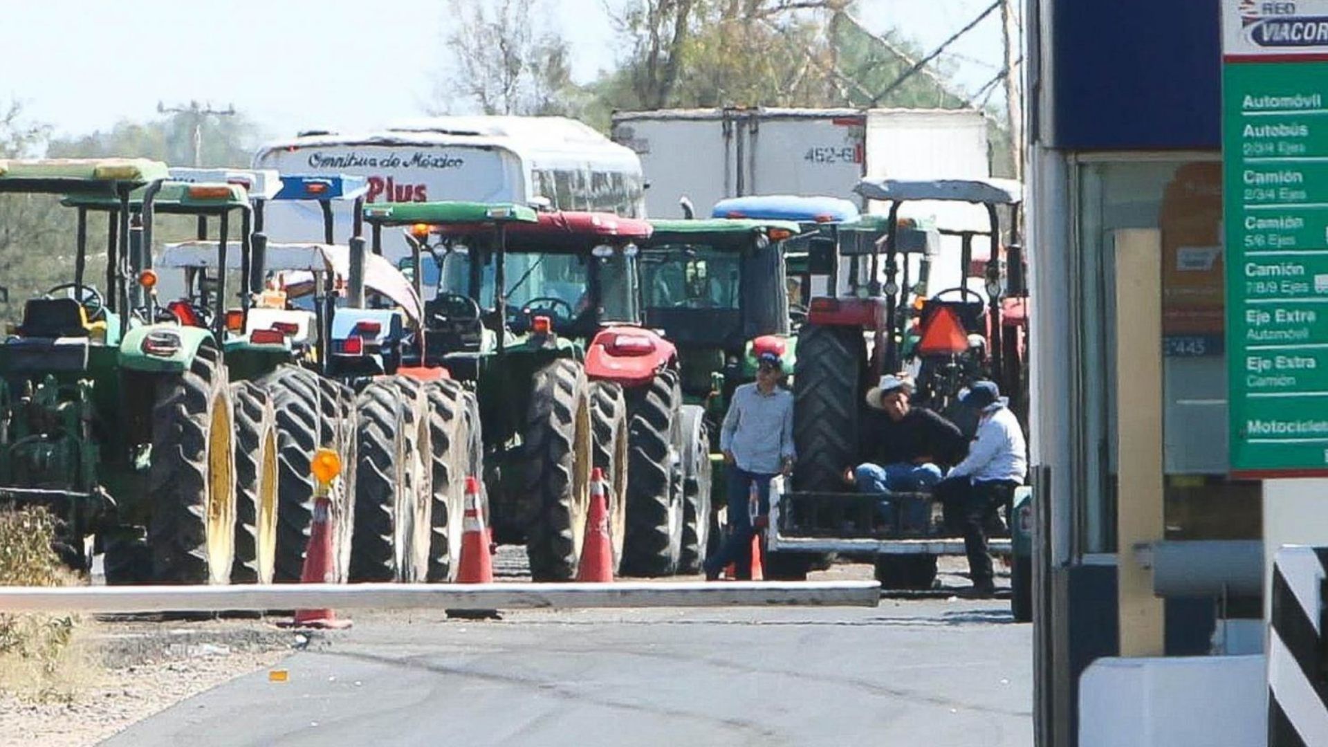Agricultores al lado de los tractores.