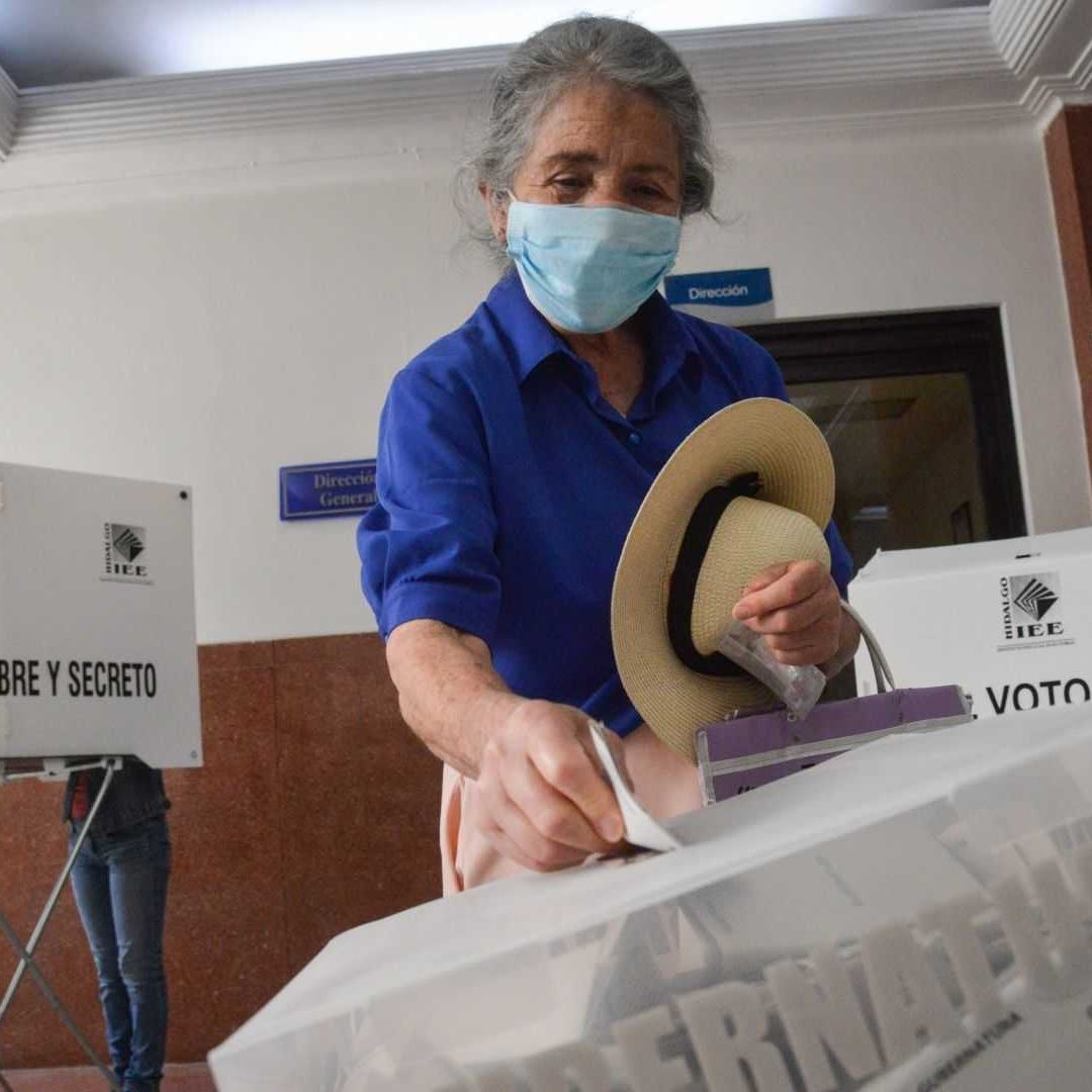 Mujer ingresando su voto a la urna