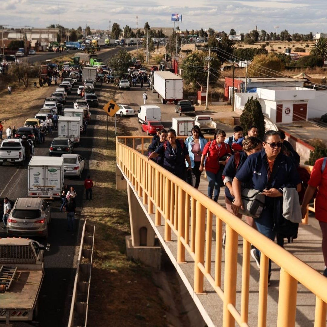 Personas caminan en un puente.