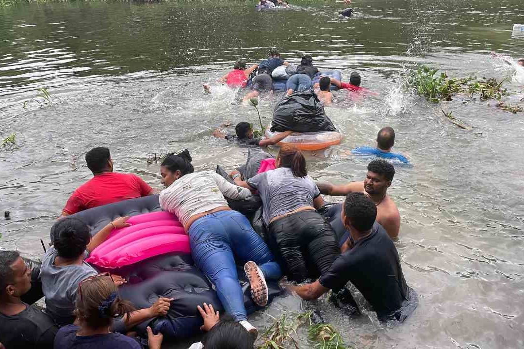 Un grupo de migrantes intentan cruzar el Río Bravo con un colchón inflable