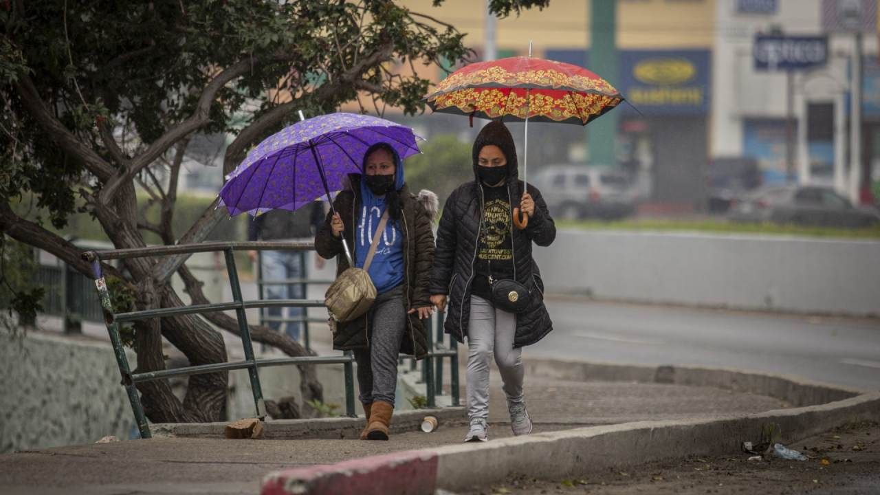Personas caminan bajo la lluvia