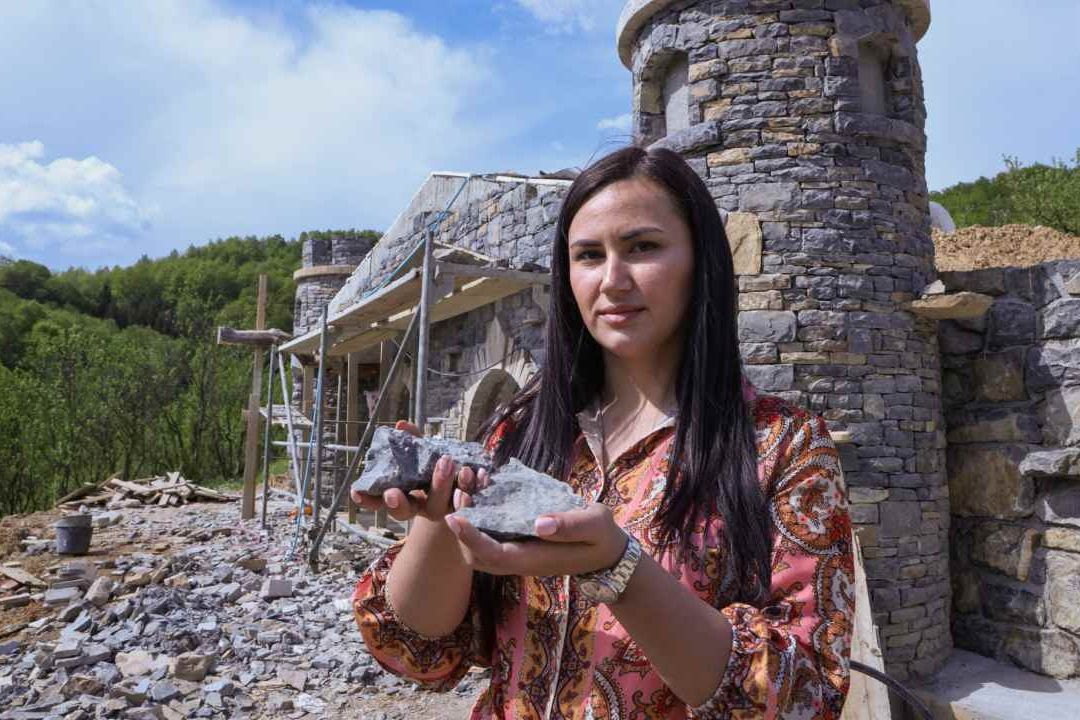 Marija Milicevic sostiene una piedra utilizada para decorar la casa hobbit llamada "Bedem", en el pueblo bosnio de Hobbiton, Rakova Noga, Bosnia y Herzegovina