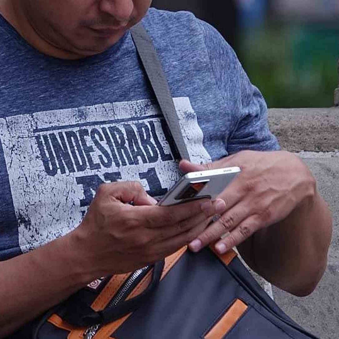 Un hombre observa su celular en la Alameda Central en mayo 2025. Foto: Cuartoscuro | Archivo 2025