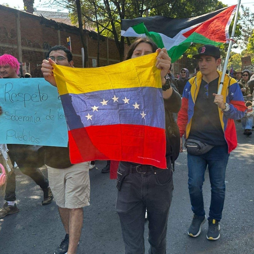 Personas integrantes portan la bandera de Venezuela.