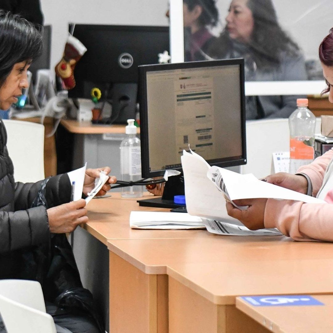 Una mujer paga sus impuestos en una oficina.