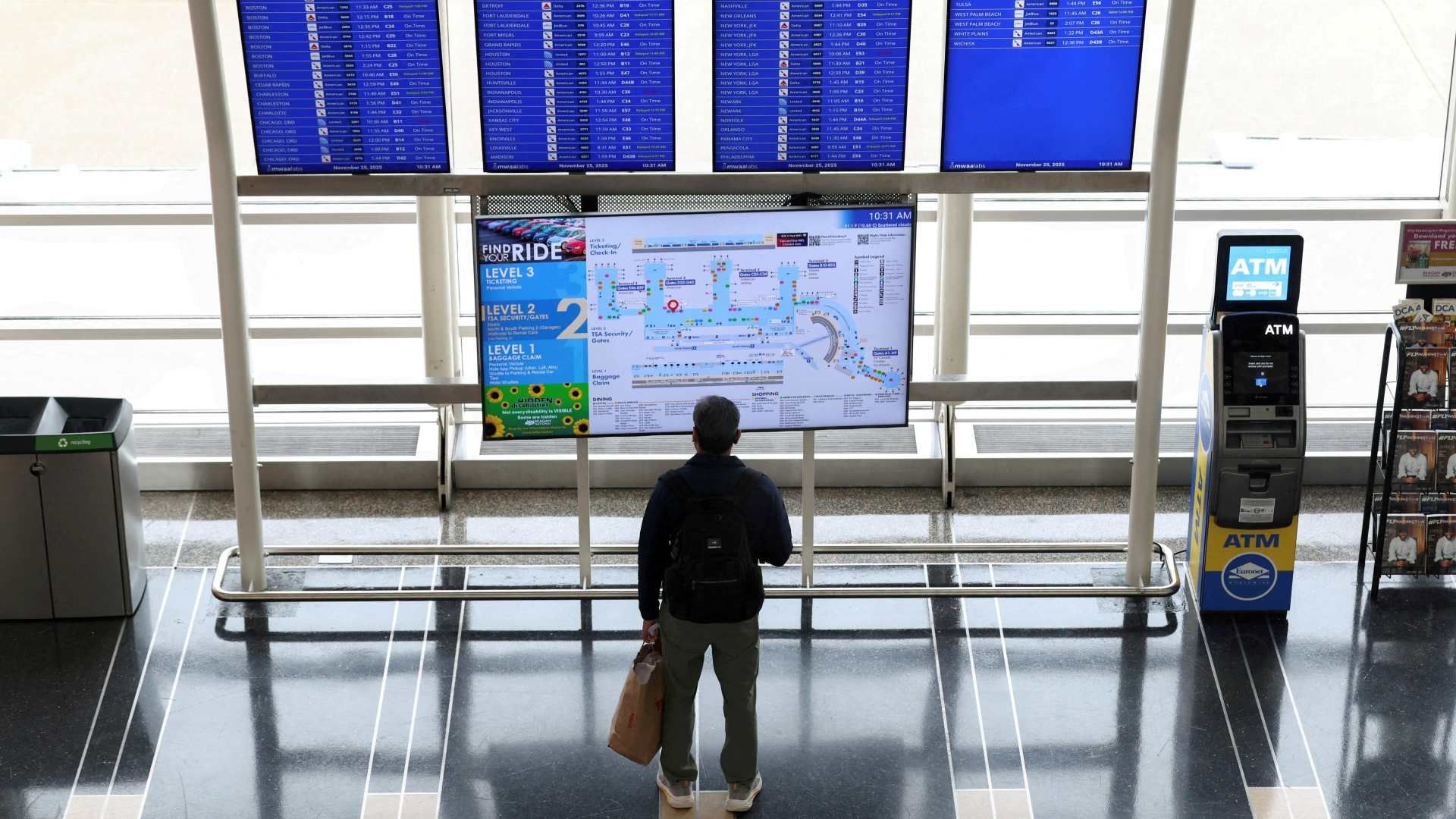 Pasajero mira panel de información de vuelos en el Aeropuerto Ronald Reagan de Washington, en noviembre 2025. Foto: Reuters