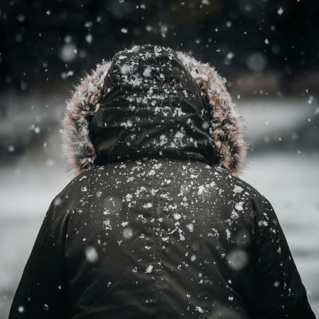 Persona con chamarra y caída de nieve