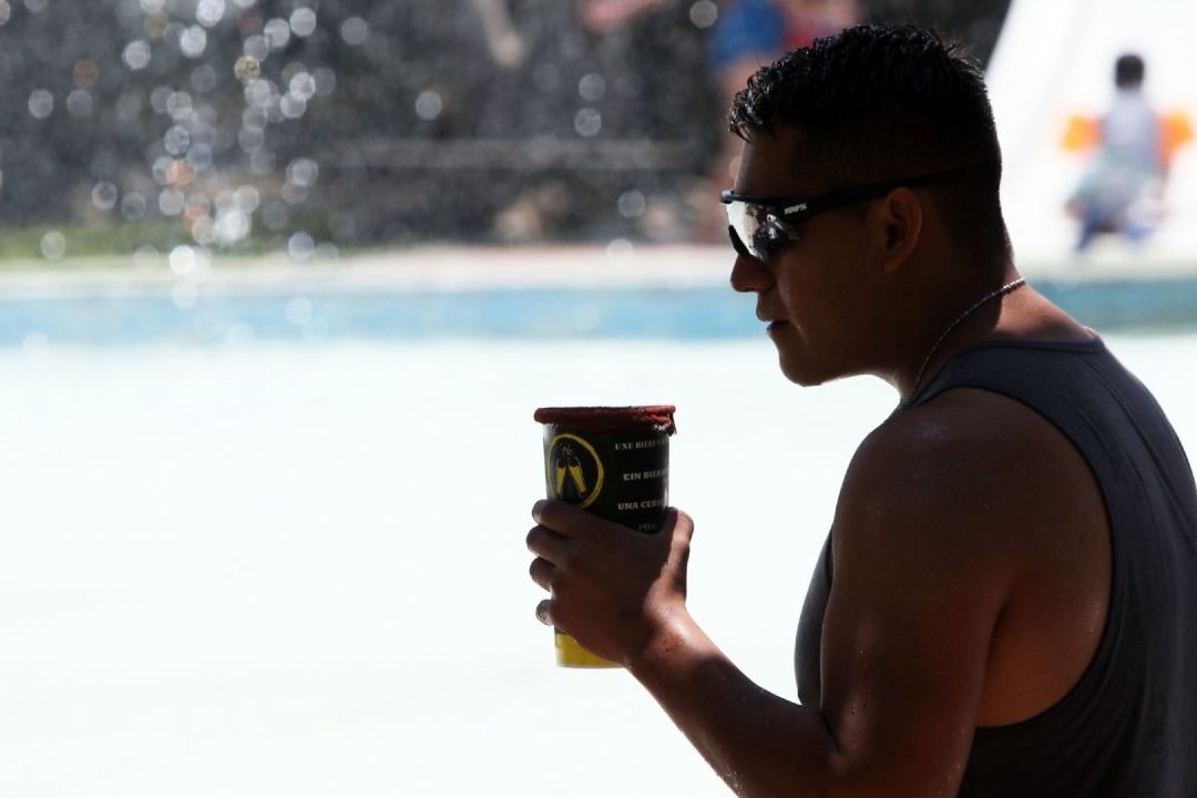 Un joven se refresca tomando una cerveza