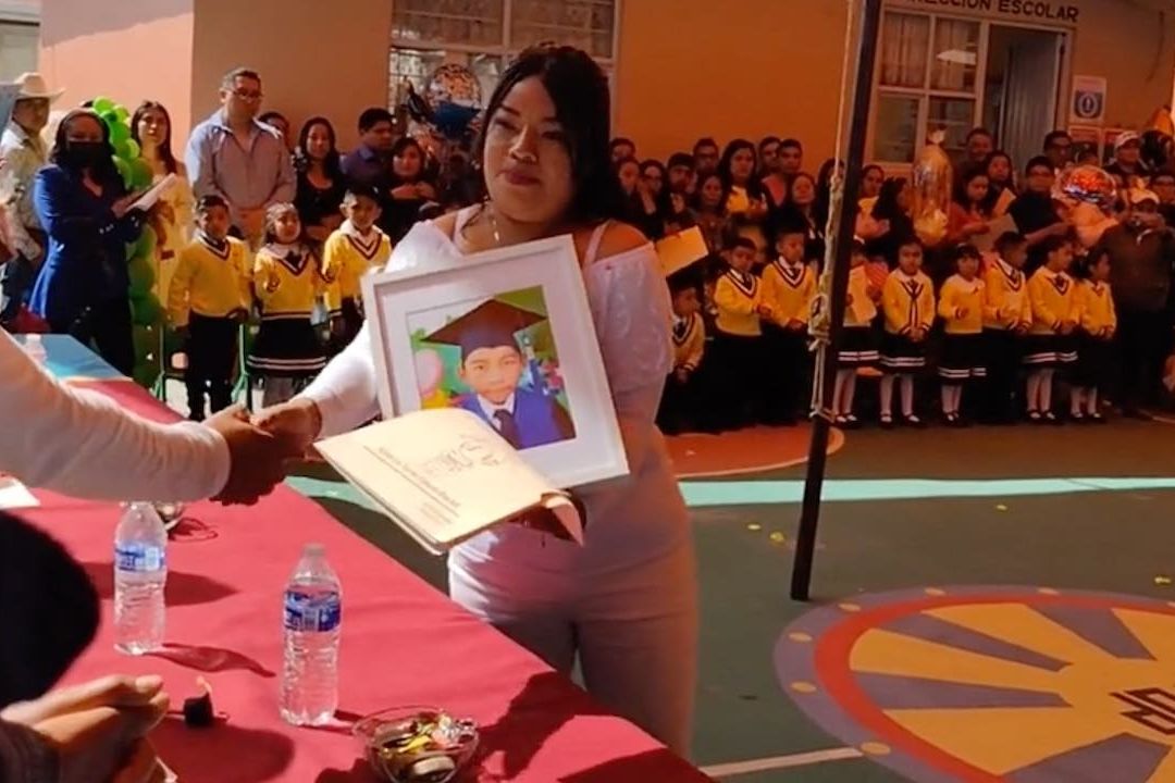 Madre leva foto de su hijo muerto a graduación del kínder