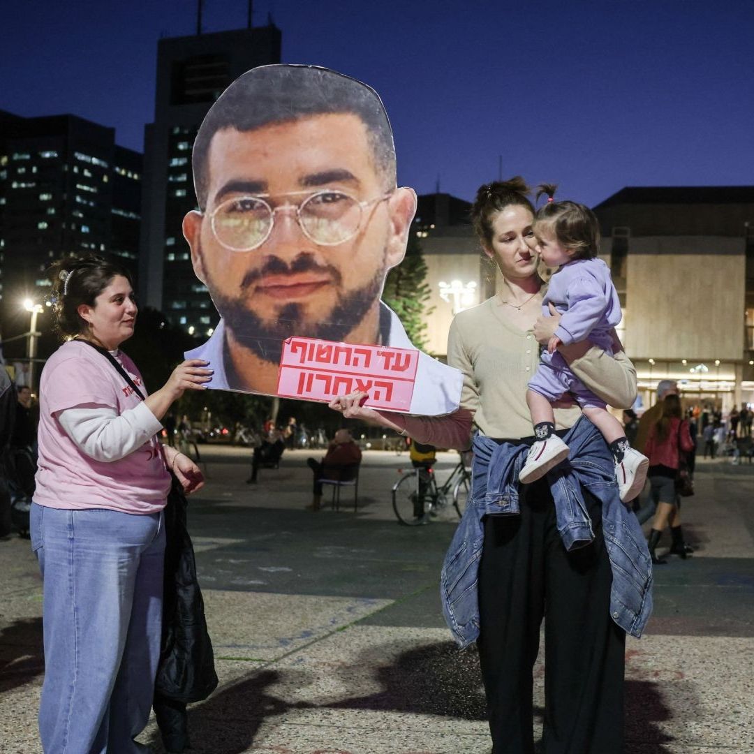 Mujeres israelíes sostienen una fotografía recortada del policía israelí Ran Gvili, secuestrado durante el ataque de Hamas del 7 de octubre de 2023.